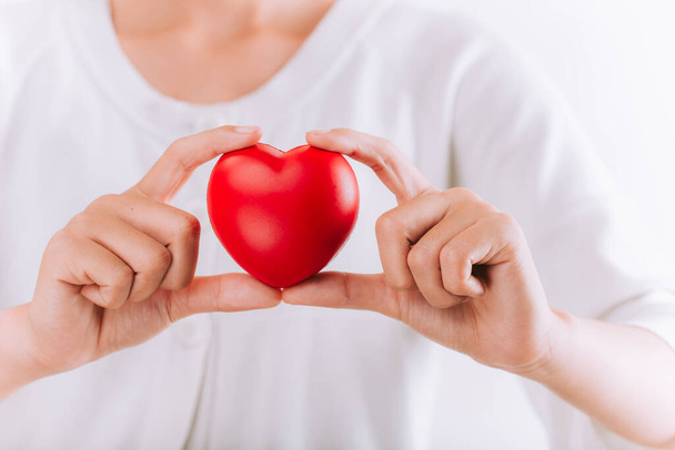 World health day, Healthcare and medical concept.Woman holding red heart in hands - Фото, изображение