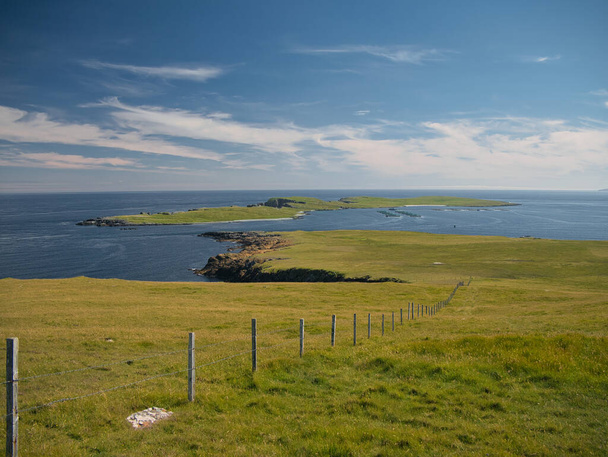 Par une journée ensoleillée avec de légers nuages, l'île de Balta depuis le Keen of Hamar près de Baltasound sur l'île d'Unst aux Shetland, en Écosse, au Royaume-Uni - Photo, image