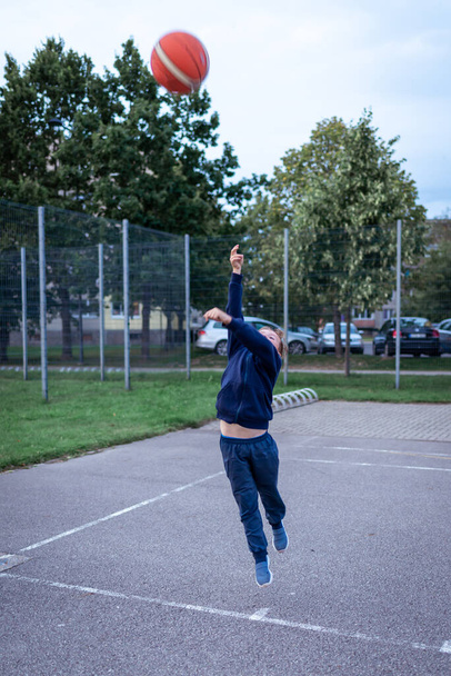 Fotografie chlapce házet basketbal ve hře náměstí - Fotografie, Obrázek