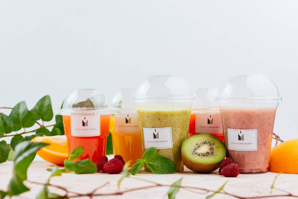 Plastic glasses with fruits smoothie, healthy drinks in to go cups - Фото, изображение