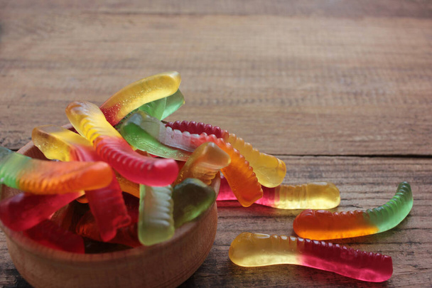 Halloween gummy worms in a bowl. Colorful jelly worms shaped candies. Top view, selective focus - Photo, Image