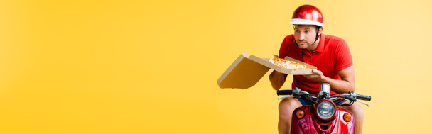 repartidor en casco a caballo scooter y la celebración de pizza en caja en amarillo, pancarta - Foto, Imagen