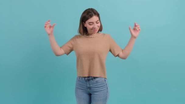 gelukkig vrouw gezet merk met vingers hart vorm, geïsoleerd op turquoise achtergrond. - Video