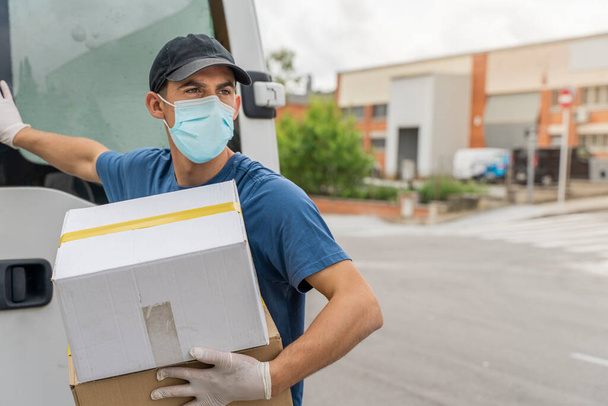 Coronavirus. Deliver man with protective mask and rubber gloves make delivery service. Delivery service under quarantine, disease outbreak, coronavirus pandemic conditions. Transportation. Heroes.  - Foto, Bild