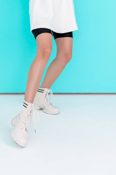 Legs of a beautiful sports girl on a blue background - Zdjęcie, obraz