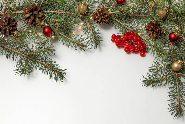 Christmas and new year holiday composition. Fir branches, cones and red viburnum berries on a white background. copy space.  - Foto, afbeelding