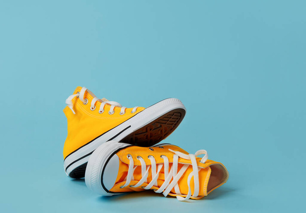 Yellow canvas shoes on blue background - Foto, immagini
