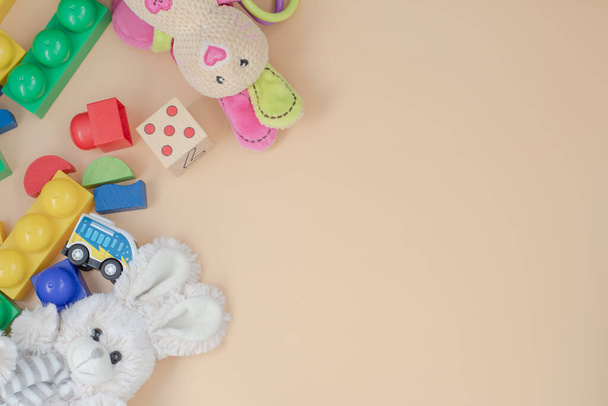 drewniane zabawki dla dzieci, klocki, pluszowy zając na beżowym tle. widok z góry - Zdjęcie, obraz
