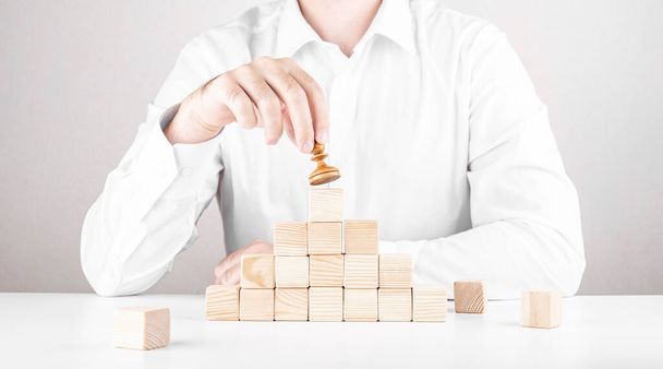 businessman climbs the career ladder. Business concept from cubes and pawn. - Fotografie, Obrázek