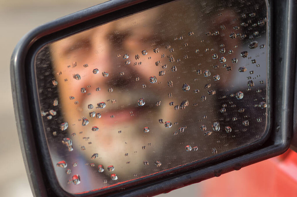 Θολή σιλουέτα του γενειοφόρου Καυκάσου ανώτερος οδηγός σε βρώμικο καθρέπτη αυτοκινήτου  - Φωτογραφία, εικόνα