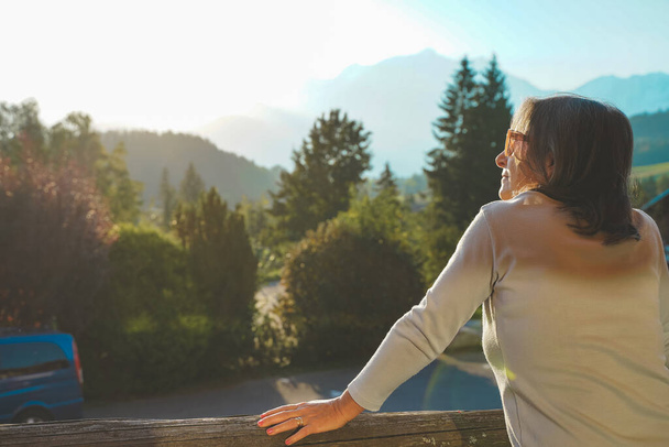 Beautiful woman enjoying amazing nature views during a sunny day. Relaxing moment with morning light.  - Foto, imagen