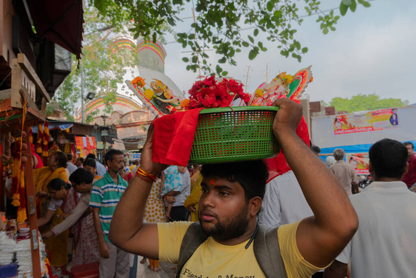 Kolkata, Bengale occidental, Inde - 15 avril 2019 : Jeune homme portant des idoles d'argile colorée de la Déesse Laxmi et du Seigneur Ganesh pour le culte, dans un seau en plastique. Image prise à Kalighat, Bengali Nouvel An, - Photo, image