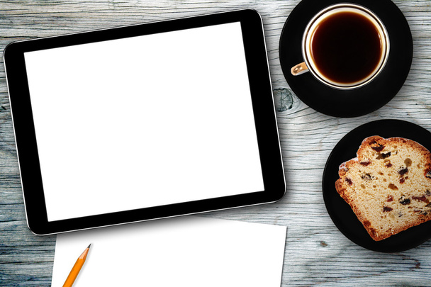 Arbeitsplatz mit digitalem Tablet, Notizbuch, Kuchen und Kaffeetasse - Foto, Bild