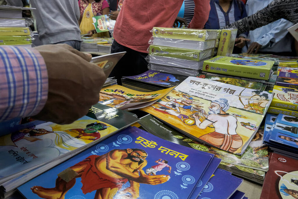 KOLKATA, INDE - 11 FÉVRIER 2018 : Les clients achètent des livres à l'intérieur d'un stand de livres à la foire du livre de Kolkata. C'est le plus grand salon du livre au monde, le plus fréquenté et le plus célèbre. - Photo, image