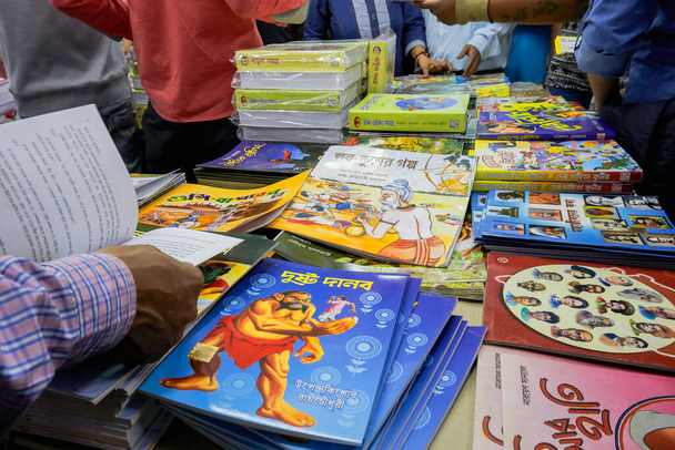 KOLKATA, INDIA - 11 DE FEBRERO DE 2018: Libros coloridos bengalíes (en idioma indio) a la venta en la feria del libro de Calcuta. Es la feria de libros no comerciales más grande, concurrida y famosa del mundo. - Foto, Imagen