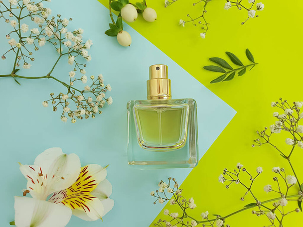 fles parfum bloem op gekleurde achtergrond - Foto, afbeelding