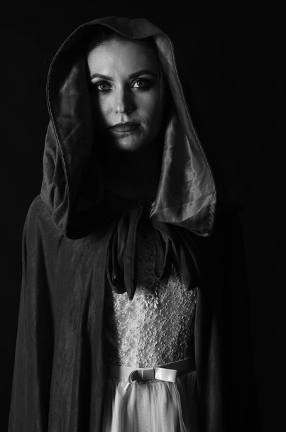 красивая женщина в плаще на темном фоне, драматические и фантастические съемки  - Фото, изображение