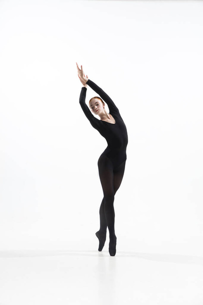Young and graceful ballet dancer in minimal black style isolated on white studio background - Fotoğraf, Görsel