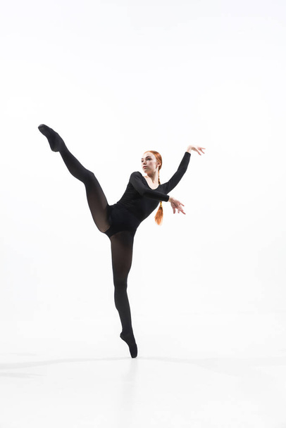 Young and graceful ballet dancer in minimal black style isolated on white studio background - Photo, image
