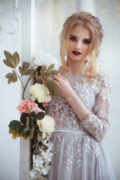 Gentle portrait of a girl bride with elegant hairdress azole garlands of flowers. - Foto, afbeelding