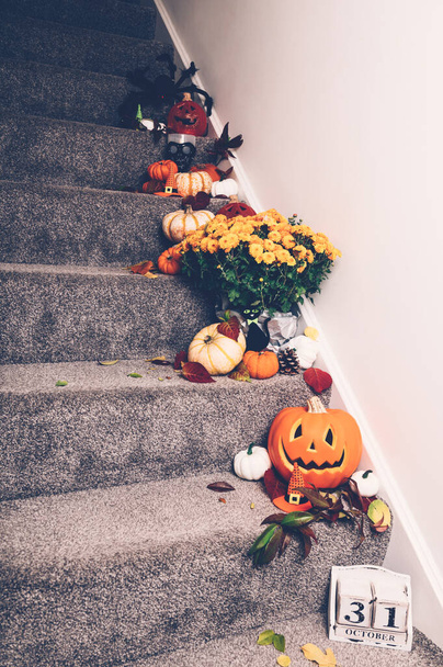 Różne rodzaje dyń i dekoracje na schodach wewnętrznych. New Normal lub Halloween podczas pandemii w domu koncepcji. Zostań w domu, uważaj na siebie.. - Zdjęcie, obraz