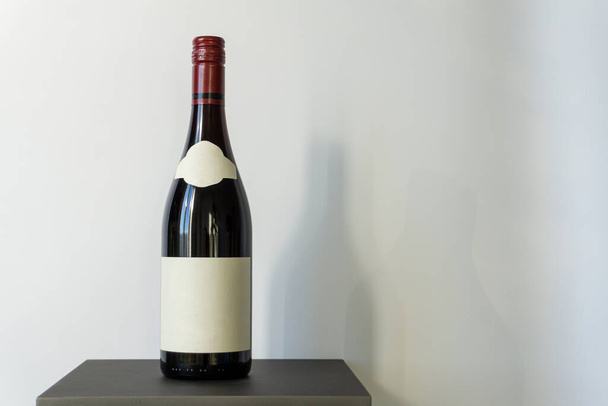 Studioaufnahme einer Weinflasche, die für Ihre Marke nicht etikettiert ist. Alkoholflasche auf einem Ständer vor weißem Hintergrund - Foto, Bild