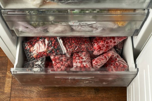 Заморозка ягод на зиму. Упакованные замороженные ягоды в пластиковые пакеты. В морозилке.. - Фото, изображение