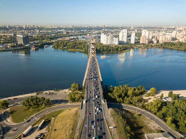 Αεροφωτογραφία τηλεκατευθυνόμενου. Αυτοκίνητο Βόρεια Γέφυρα στο Κίεβο κατά μήκος του ποταμού Δνείπερου. Ηλιόλουστη μέρα. - Φωτογραφία, εικόνα
