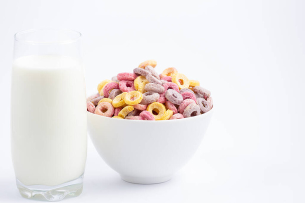 Mais-Müsli-Frühstücksflocke in Kinderbechern und Milch ist ein gesundes Frühstück, das jeden Tag auf weißem Hintergrund gut für den Körper ist. - Foto, Bild