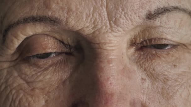 Eyes of senior woman looks at camera - Záběry, video