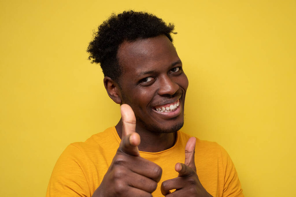 Αστείος νεαρός Αφρικανός χαμογελάει ευτυχισμένος και δείχνει τα δάχτυλα του στην κάμερα. - Φωτογραφία, εικόνα