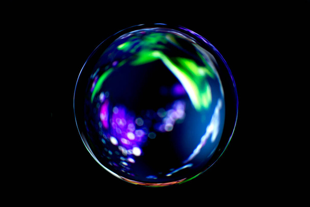 Wazig beeld van een glanzende kristallen bol met abstracte wazige kleurrijke patroon. Abstracte lenzenbal in vervaging. - Foto, afbeelding