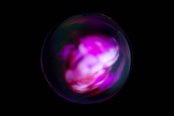 Wazig beeld van een glanzende kristallen bol met abstracte wazige kleurrijke patroon. Abstracte lenzenbal in vervaging. - Foto, afbeelding