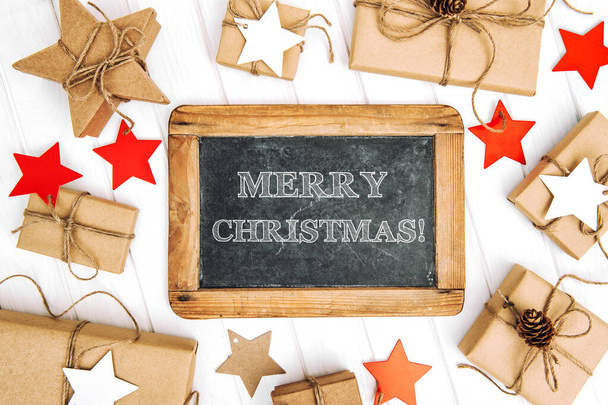 Merry Christmas! Craft paper wrapped gifts with star decoration and chalkboard - Photo, image