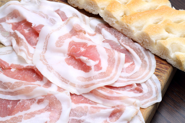 Bacon slices with focaccia on wooden cutting board - Photo, Image