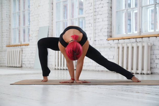 Athletic girl doing yoga in the gym. - Фото, зображення
