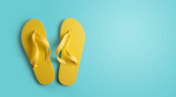 Keltaiset sandaalit sinisellä pohjalla, jossa on tilaa tekstillesi. kesäkonsepti - Valokuva, kuva