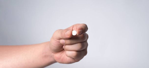 Close-up images of people taking or holding a medicine pill in hand which help and protect from pandemic virus and relief them from unhealthy and sickness. studio shot and clear background. - Photo, image