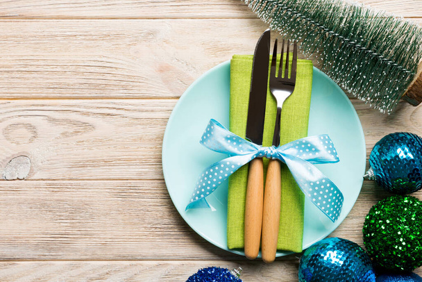 Σύνθεση διακοπών του Χριστουγεννιάτικου δείπνου σε ξύλινο φόντο. Κάτοψη του πιάτου, σκεύος και γιορτινή διακόσμηση. Πρωτοχρονιά Advent έννοια με αντίγραφο χώρου. - Φωτογραφία, εικόνα
