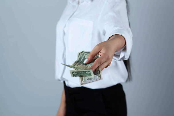 young woman hand money on grey background - Zdjęcie, obraz