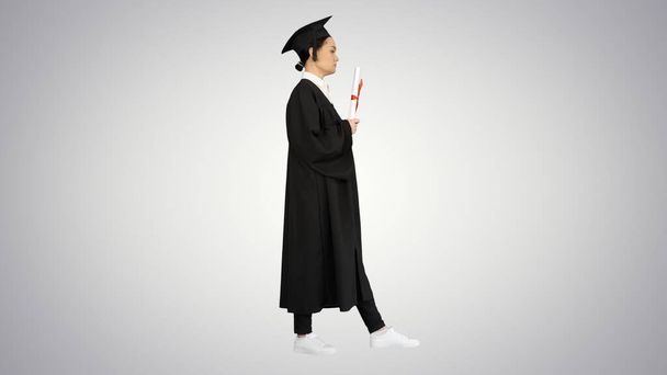 Разочарованная студентка в выпускном халате трясет дипломом - Фото, изображение