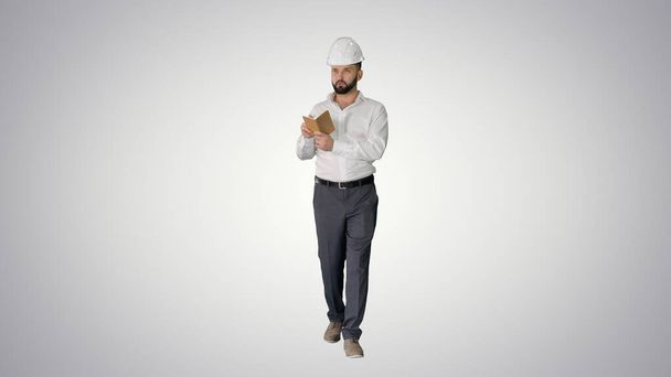 Confident mature man in formalwear and hardhat writing down note - Foto, Bild