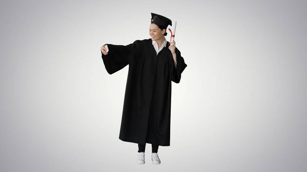 Happy female graduate holding diploma and making selfie on her p - Foto, imagen