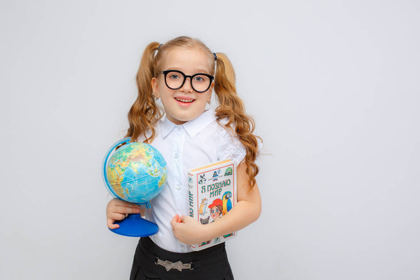 little girl holding globe and book - Fotó, kép