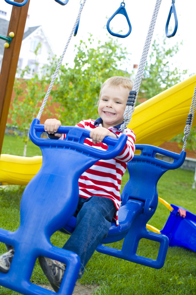 four-year-old child riding a swing - Φωτογραφία, εικόνα