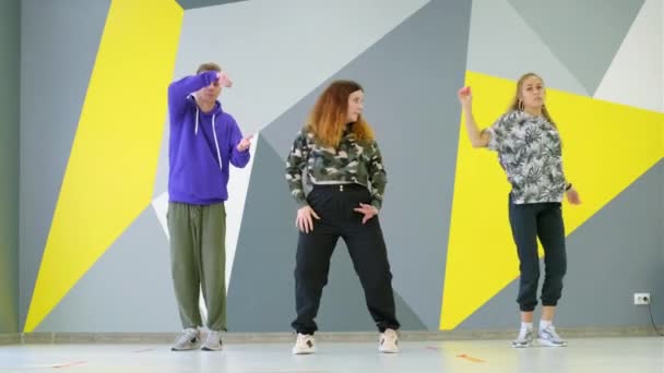Een man en twee vrouwen dansen hiphop, een vrije stijl hedendaagse dans in een muziekstudio. - Video