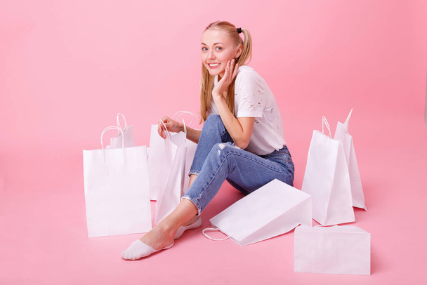 menina em uma camiseta branca com compras em um fundo rosa. Sexta-feira negra. Cyber Monday - Foto, Imagem