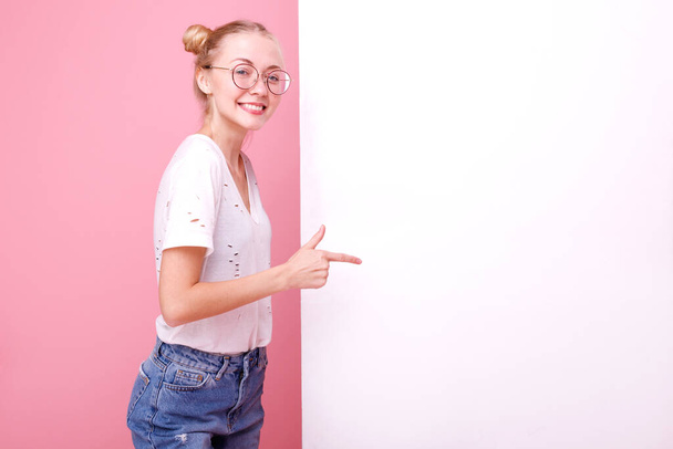 Κορίτσι αναδεικνύει λευκό πανό για κείμενο στο στούντιο - Φωτογραφία, εικόνα