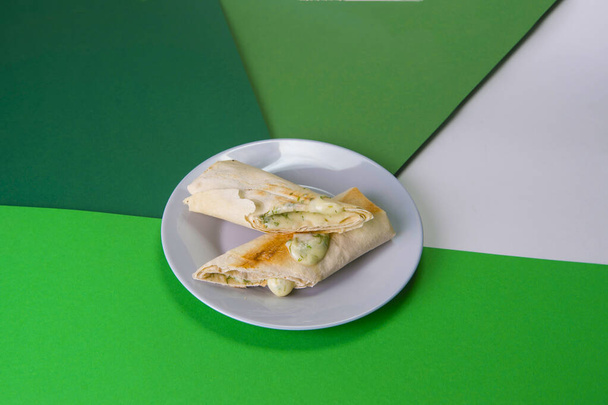 Грузинские традиционные жареные булочки лаваш (пита) с сыром сулугуни и зелеными травами (укроп). обеденный стол на серой тарелке на красочном фоне - Фото, изображение