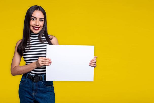 Woman holding white sign, isolated on yellow background with space for text. - Photo, Image